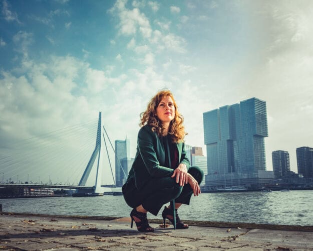 Vrouw gehurkt op de kade in Rotterdam
